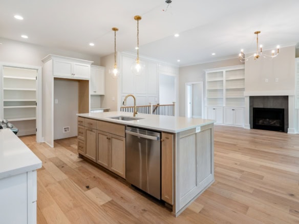 Bright, spacious kitchen with island, white cabinets, and hardwood floors.