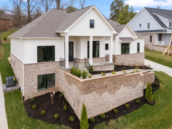 New construction home with white siding and brick foundation at 7517 Beechspring Farm Blvd.