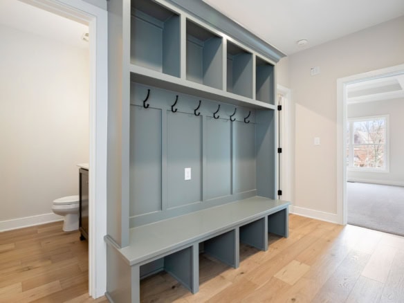 Modern mudroom with built-in storage and hooks at 7517 Beechspring Farm Blvd.
