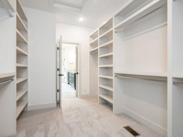 Walk-in closet with built-in shelves and hanging rods for clothing storage.