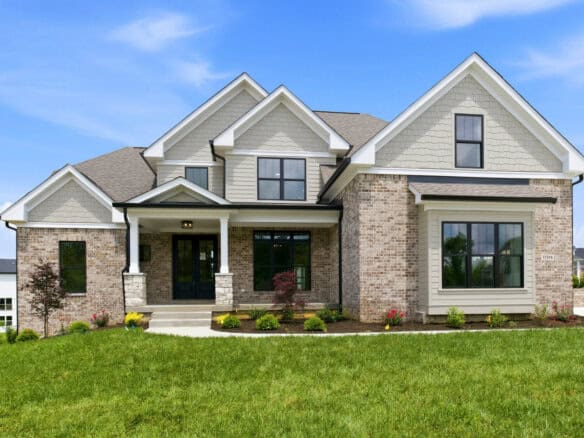 Luxury modern home with brick and siding exterior, large windows, and landscaped yard.