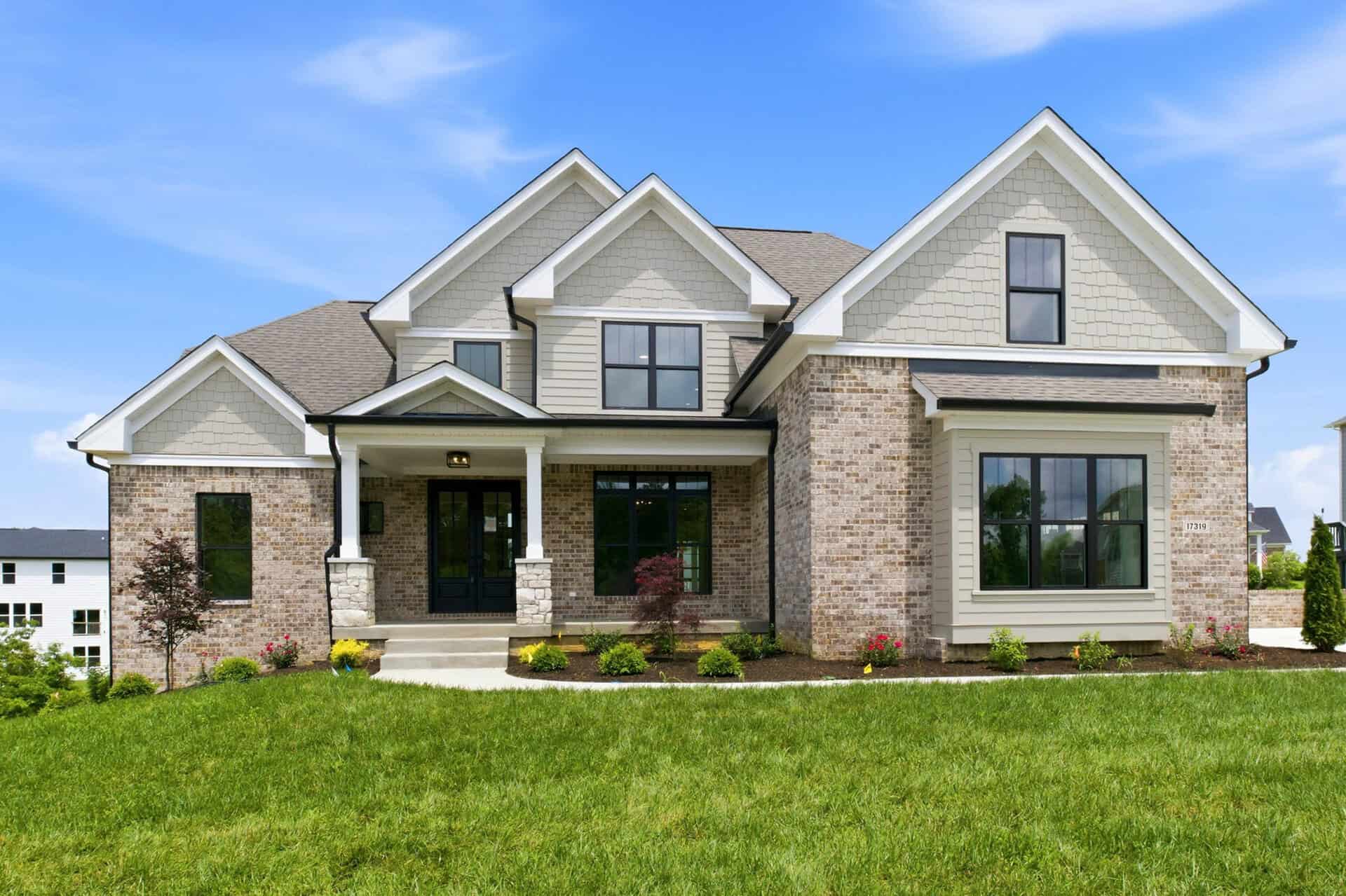 Photography by asmedia Luxury modern home with brick and siding exterior, large windows, and landscaped yard.