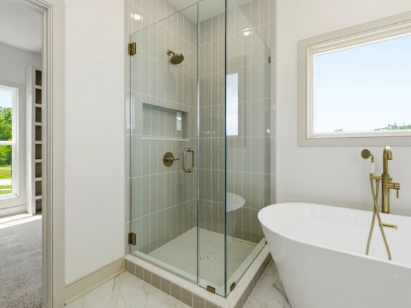 Modern bathroom with glass shower and freestanding tub in a luxury home.