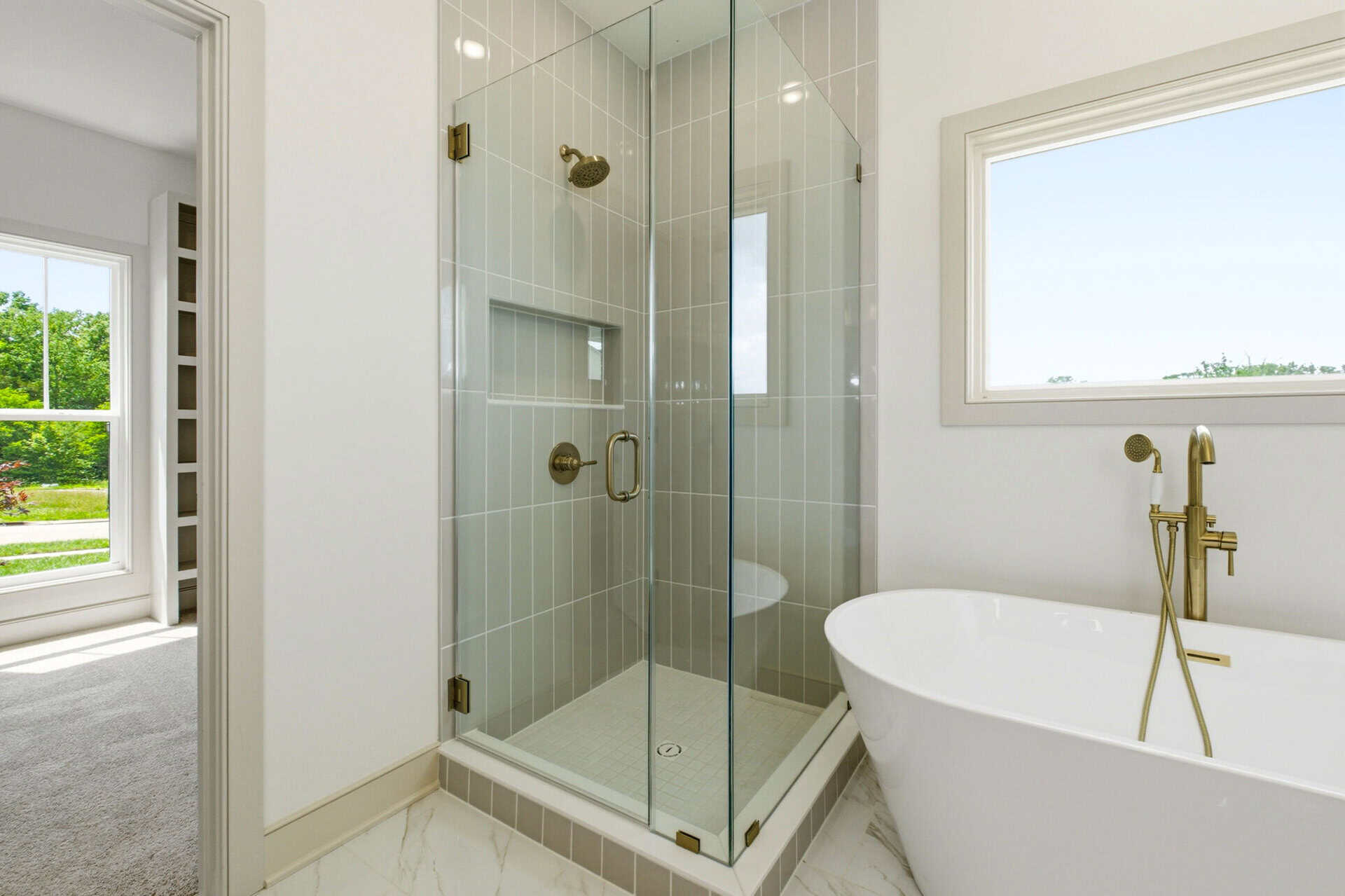Modern bathroom with glass shower and freestanding tub in a luxury home.