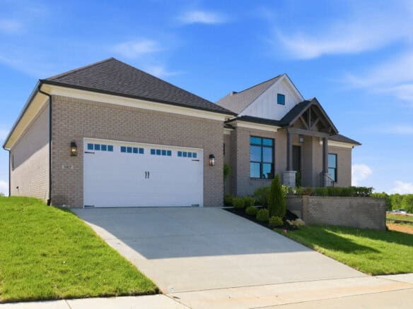Modern brick home with a two-car garage and landscaped front yard.