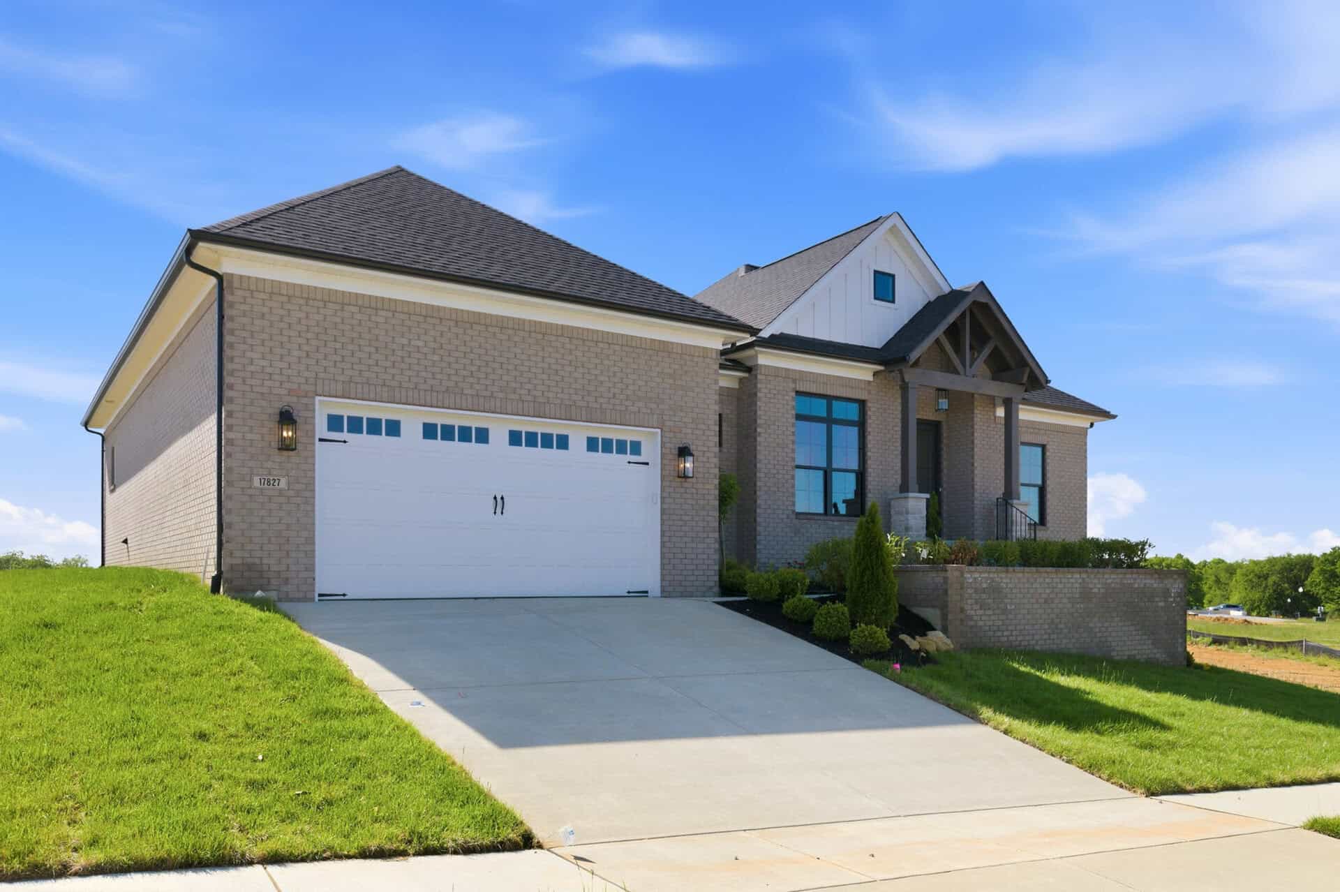 Modern brick home with a two-car garage and landscaped front yard.