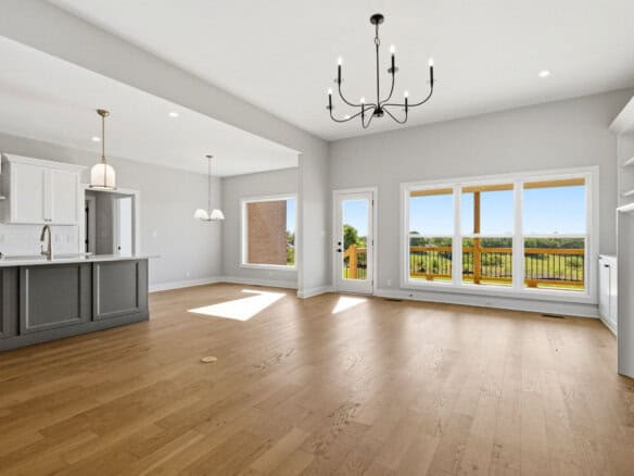 Spacious living area with large windows and hardwood floors in a modern home.