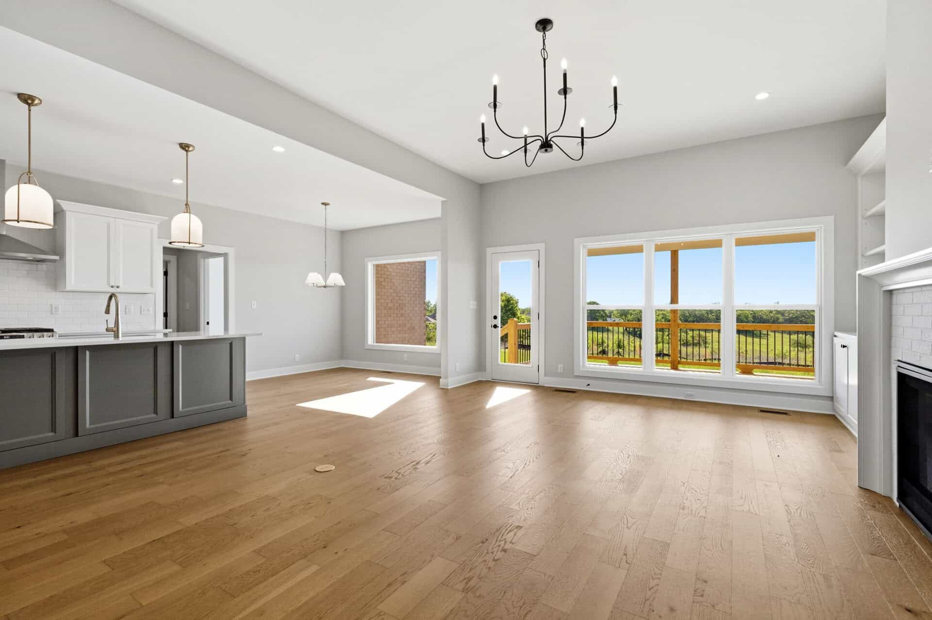 Spacious living area with large windows and hardwood floors in a modern home.