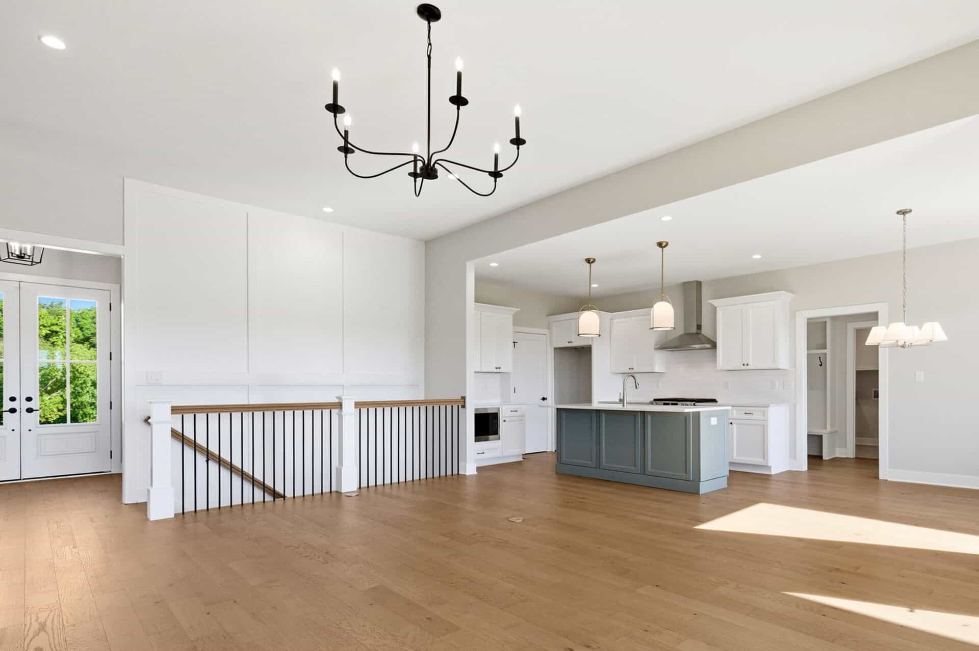 Spacious open-concept kitchen and living area with hardwood floors and modern lighting.