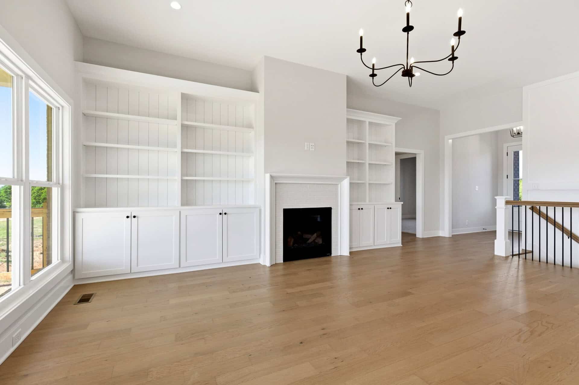 Spacious living room with white built-in shelves and a fireplace.
