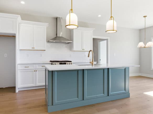 Modern kitchen with white cabinets and blue island in a bright home.