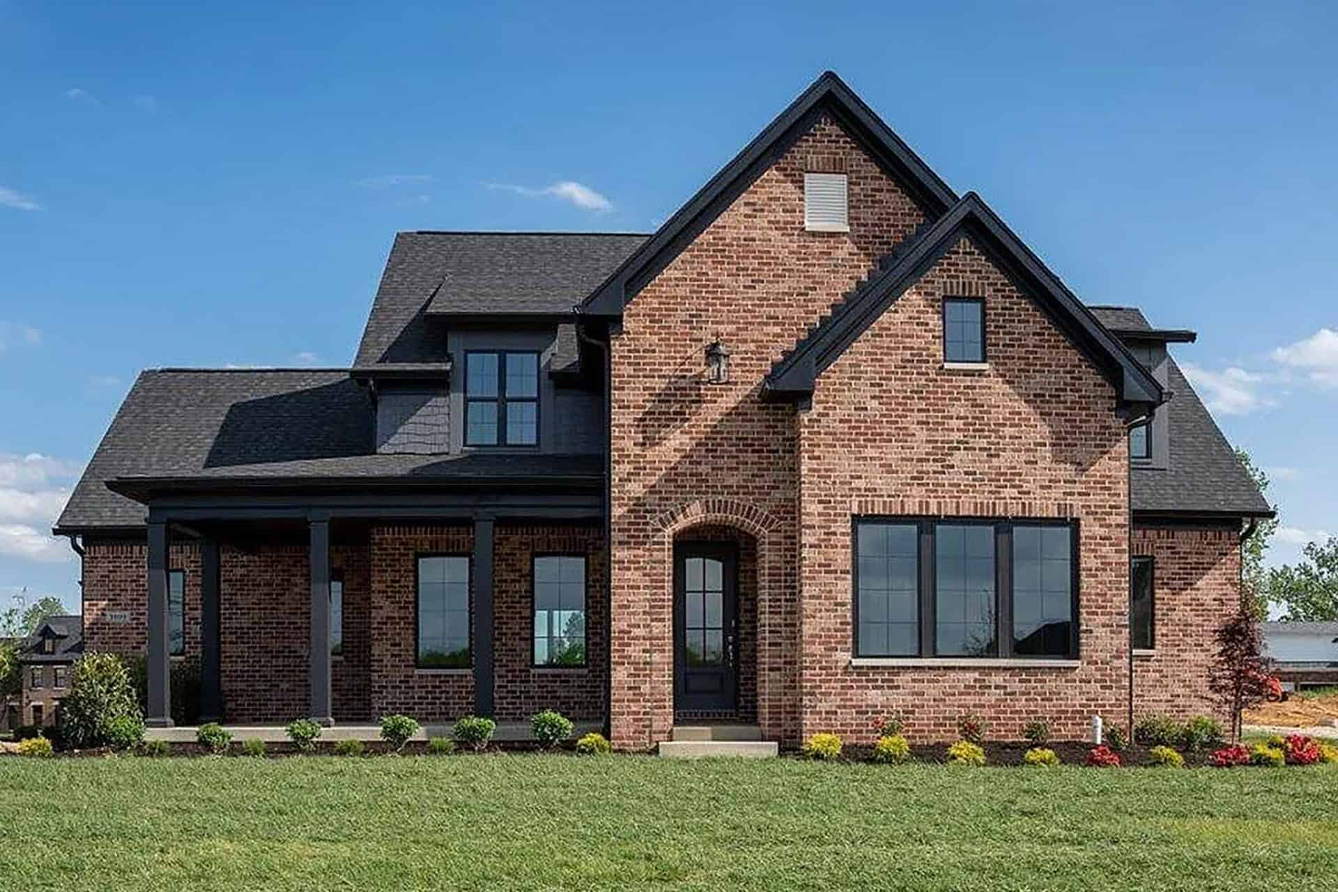 3000 Quarry Road-2 Elegant brick home with multiple gables and large windows in a lush yard.