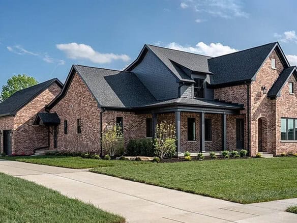 Luxury brick home with multiple gabled roofs and landscaped yard in Louisville, KY.