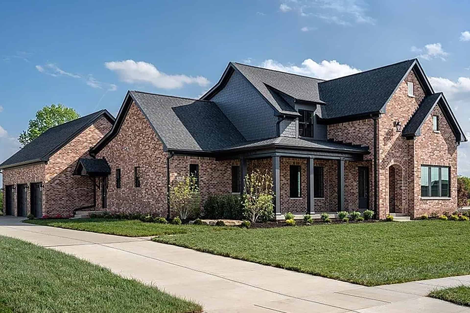 Luxury brick home with multiple gabled roofs and landscaped yard in Louisville, KY.