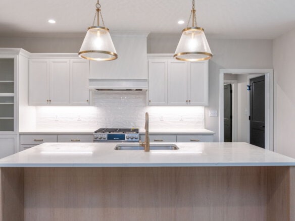 Modern kitchen with white cabinets, island, and pendant lighting.
