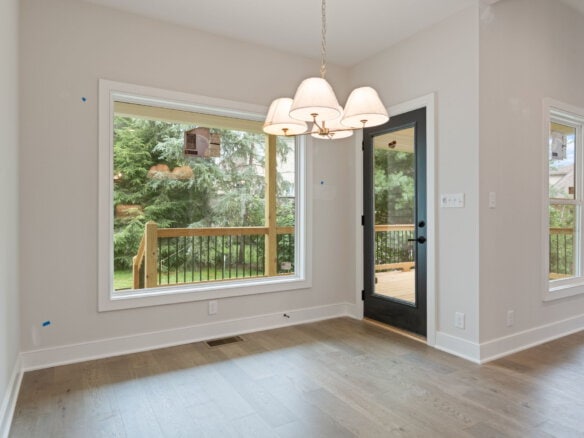 Bright dining area with large window and glass door leading to deck.