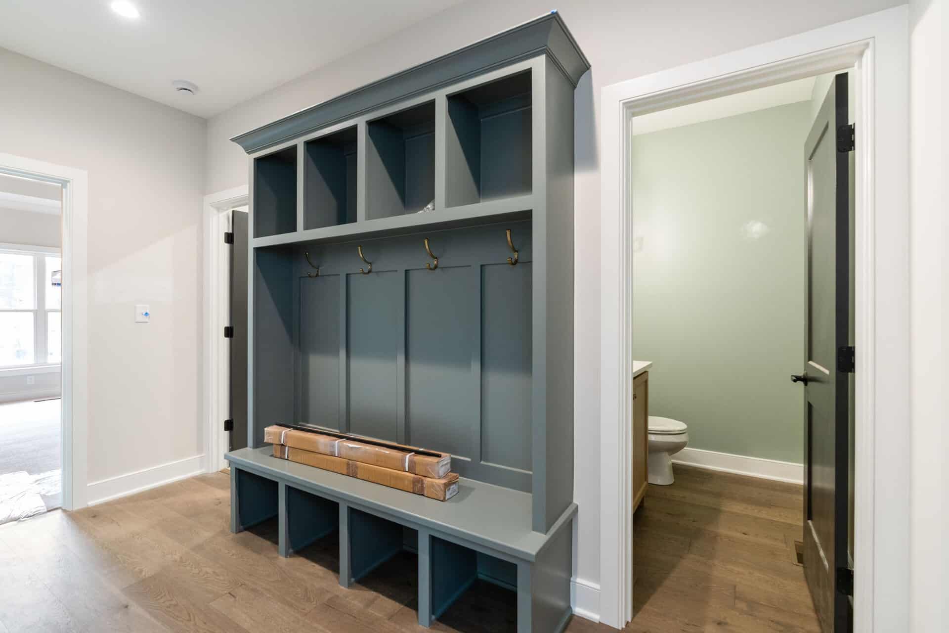 Custom mudroom with hooks and storage bench in a modern home.