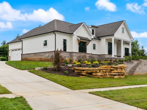 Modern white custom home with stone accents and landscaped yard in Louisville, KY.