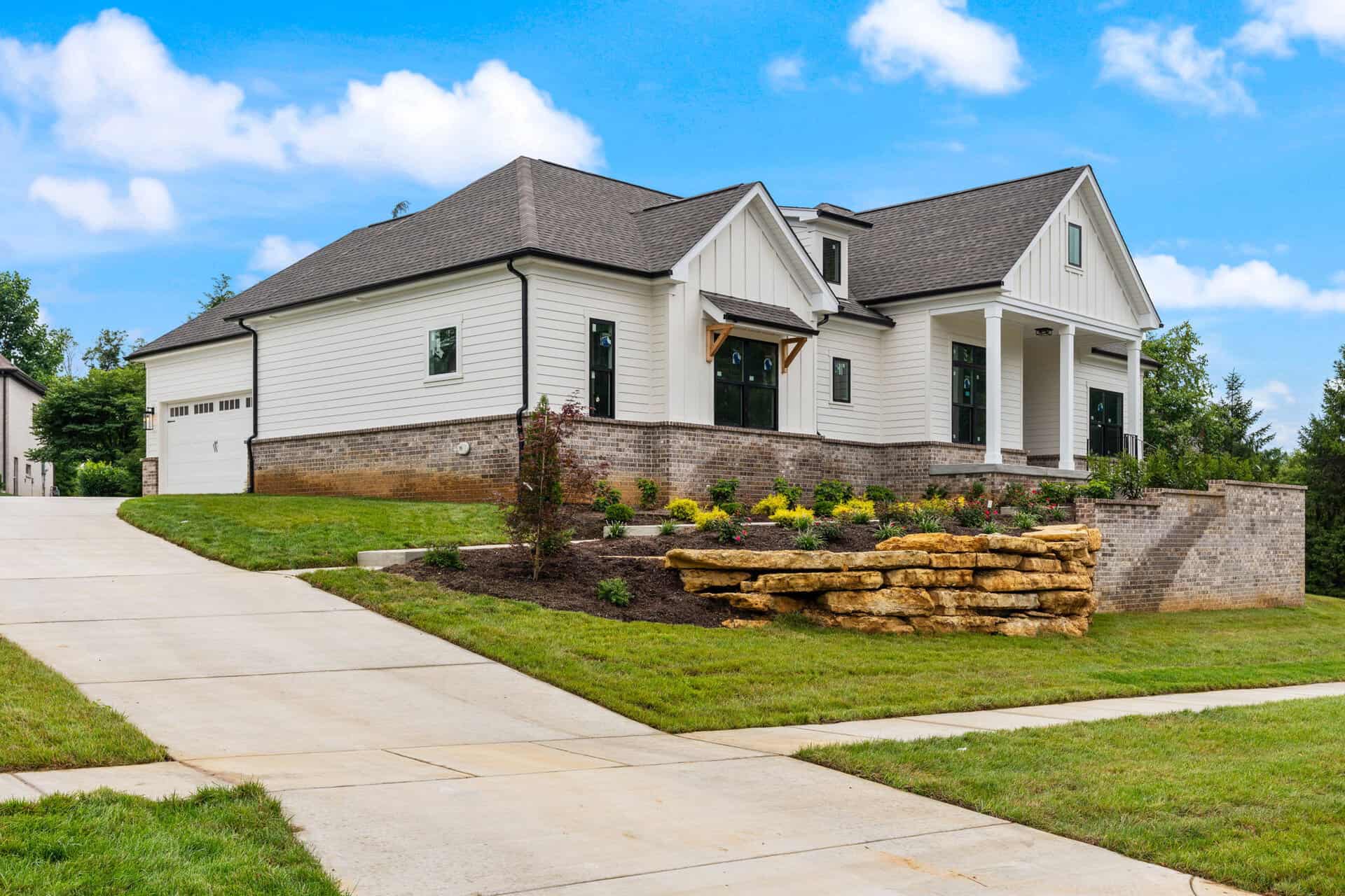 Modern white custom home with stone accents and landscaped yard in Louisville, KY.