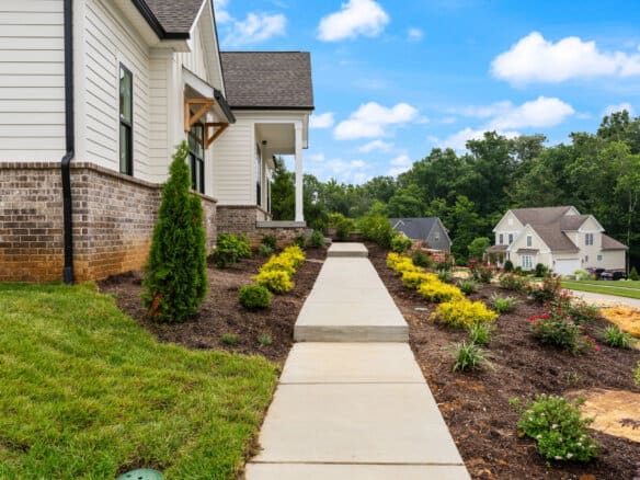 Newly landscaped front yard with walkway and garden beds in Louisville, KY.