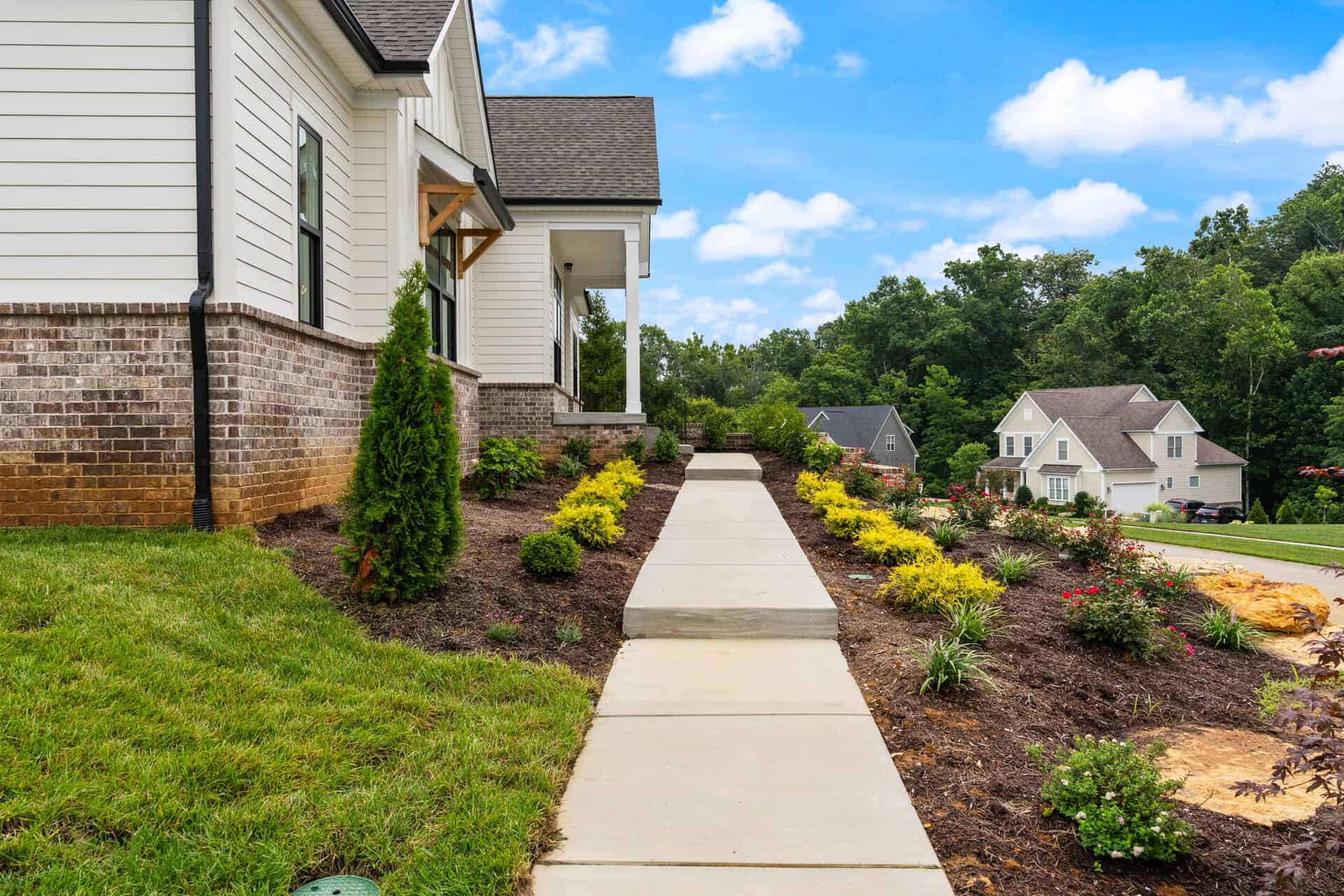 Newly landscaped front yard with walkway and garden beds in Louisville, KY.