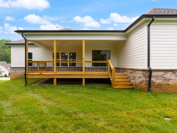 Newly built backyard deck with stairs and railing in a suburban home.