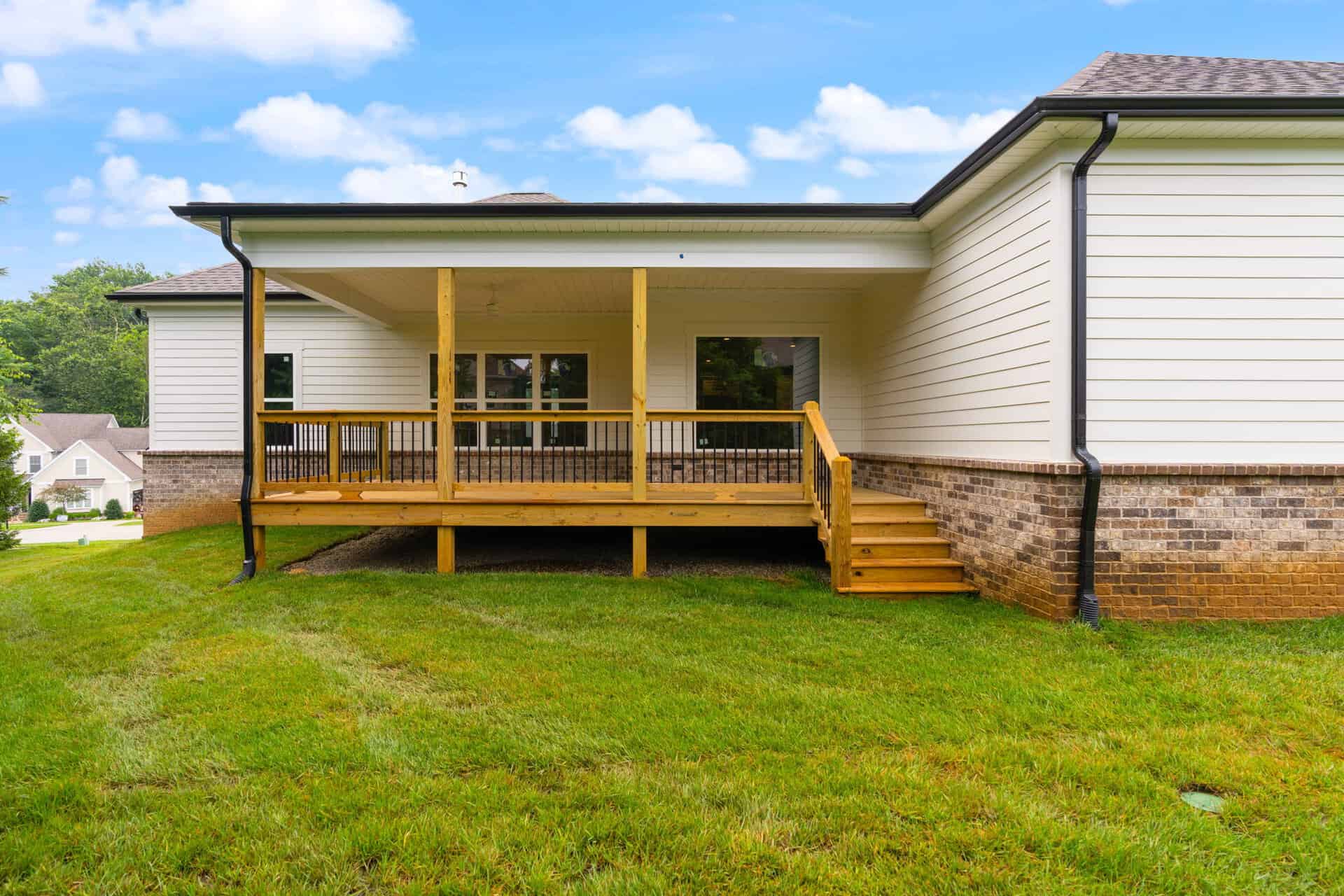 Newly built backyard deck with stairs and railing in a suburban home.