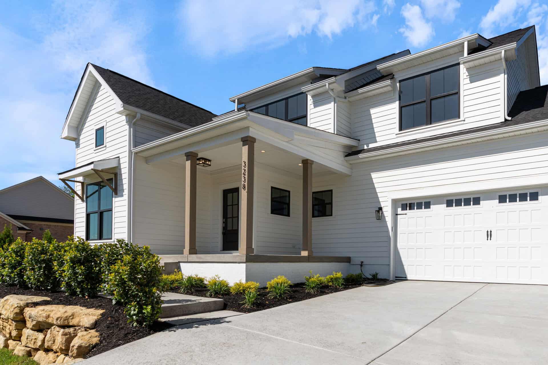 Modern white house with black window frames and a two-car garage.