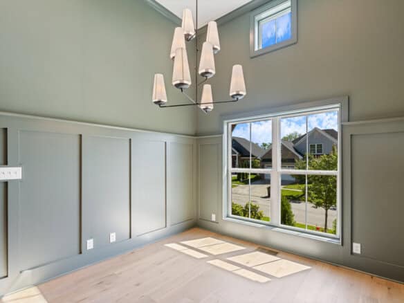 Bright living room with large window and modern chandelier in a new home.