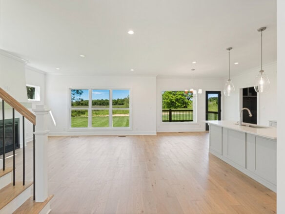 Spacious open-concept living area with large windows and modern kitchen.