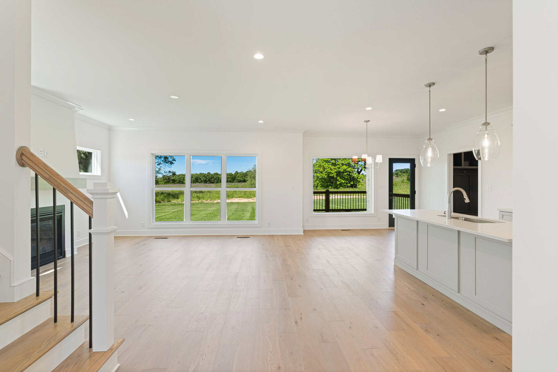 Spacious open-concept living area with large windows and modern kitchen.