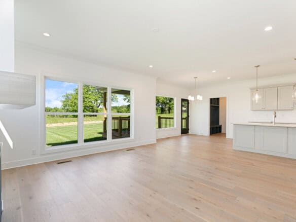 Spacious open-concept kitchen and living area with large windows and hardwood floors.