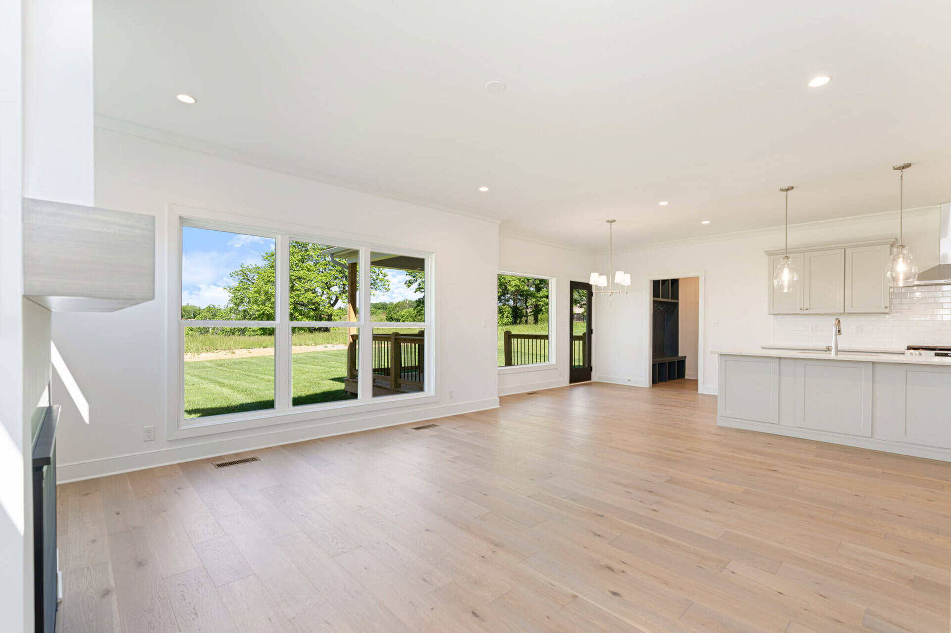 Spacious open-concept kitchen and living area with large windows and hardwood floors.