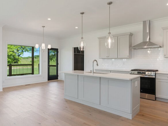 Modern kitchen with white cabinets, island, and stainless steel appliances.