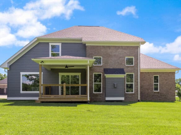 Modern two-story house with a spacious backyard and a covered porch.