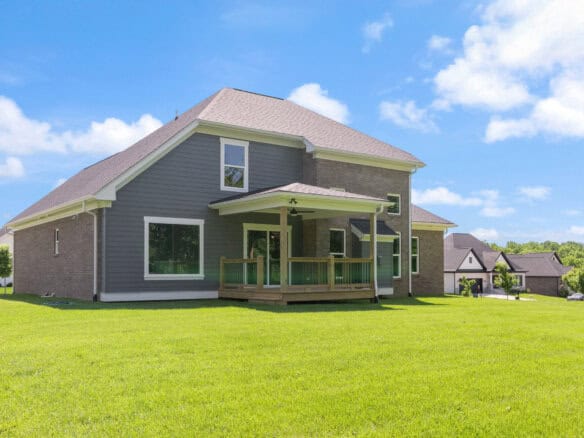 Modern two-story house with a large backyard and a wooden deck in Louisville, KY.