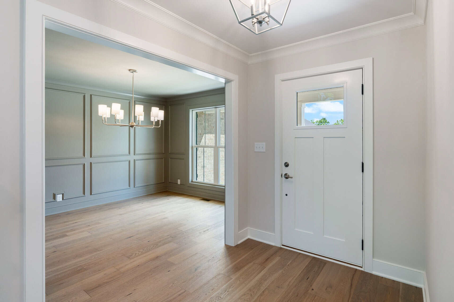 Bright entryway with white door and natural light in a modern home.