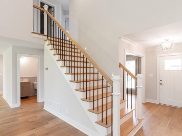 Bright foyer with staircase and hardwood floors in a modern home.