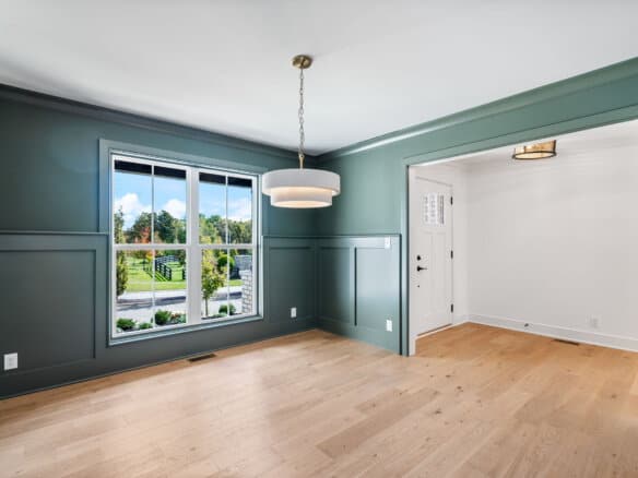 Bright living room with large window and hardwood floors in a new home.