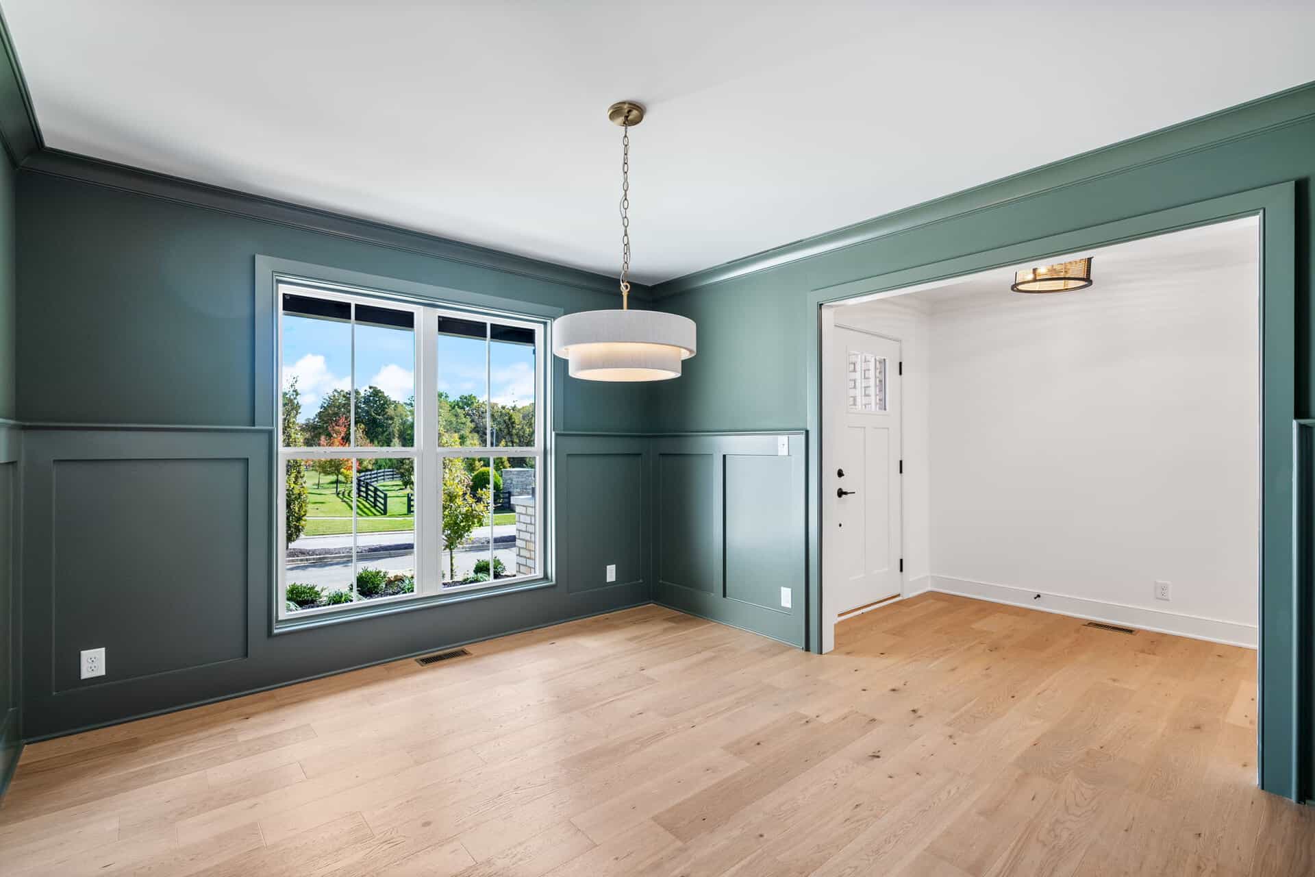 Bright living room with large window and hardwood floors in a new home.