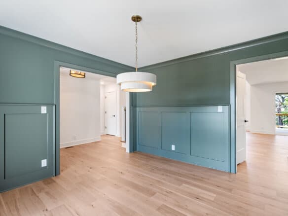 Modern interior with green wall paneling and hardwood floors in a home.