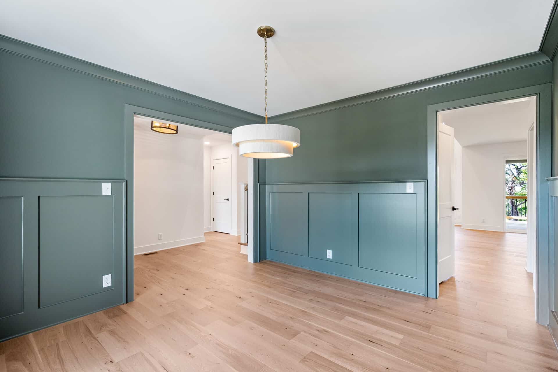 Modern interior with green wall paneling and hardwood floors in a home.