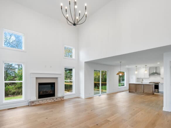 Spacious living room with high ceilings, large windows, and modern fireplace.