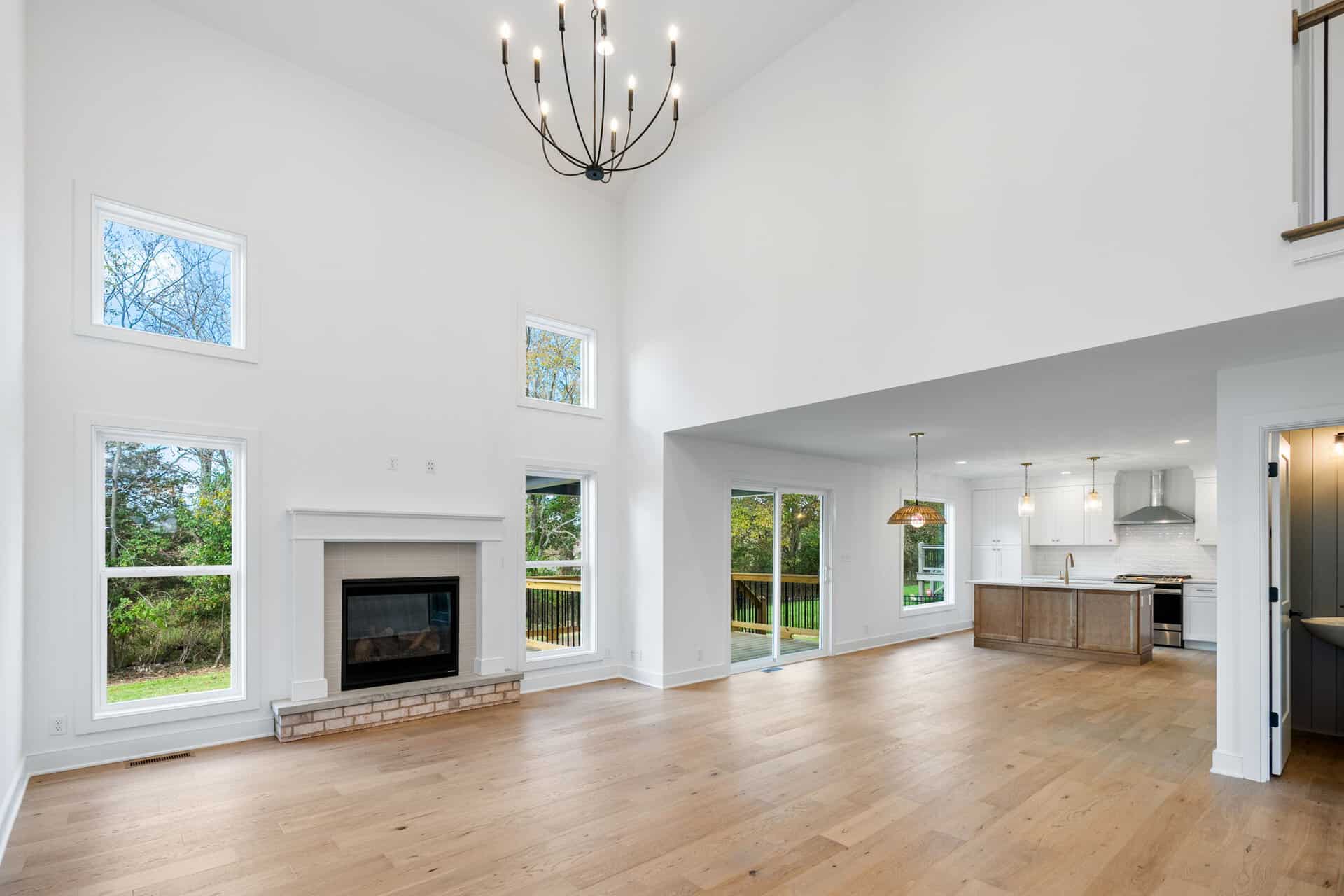 Spacious living room with high ceilings, large windows, and modern fireplace.
