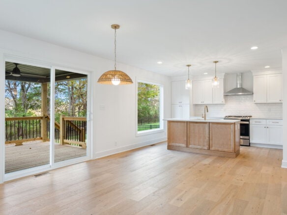Open-concept kitchen and dining area with large sliding glass door to deck.