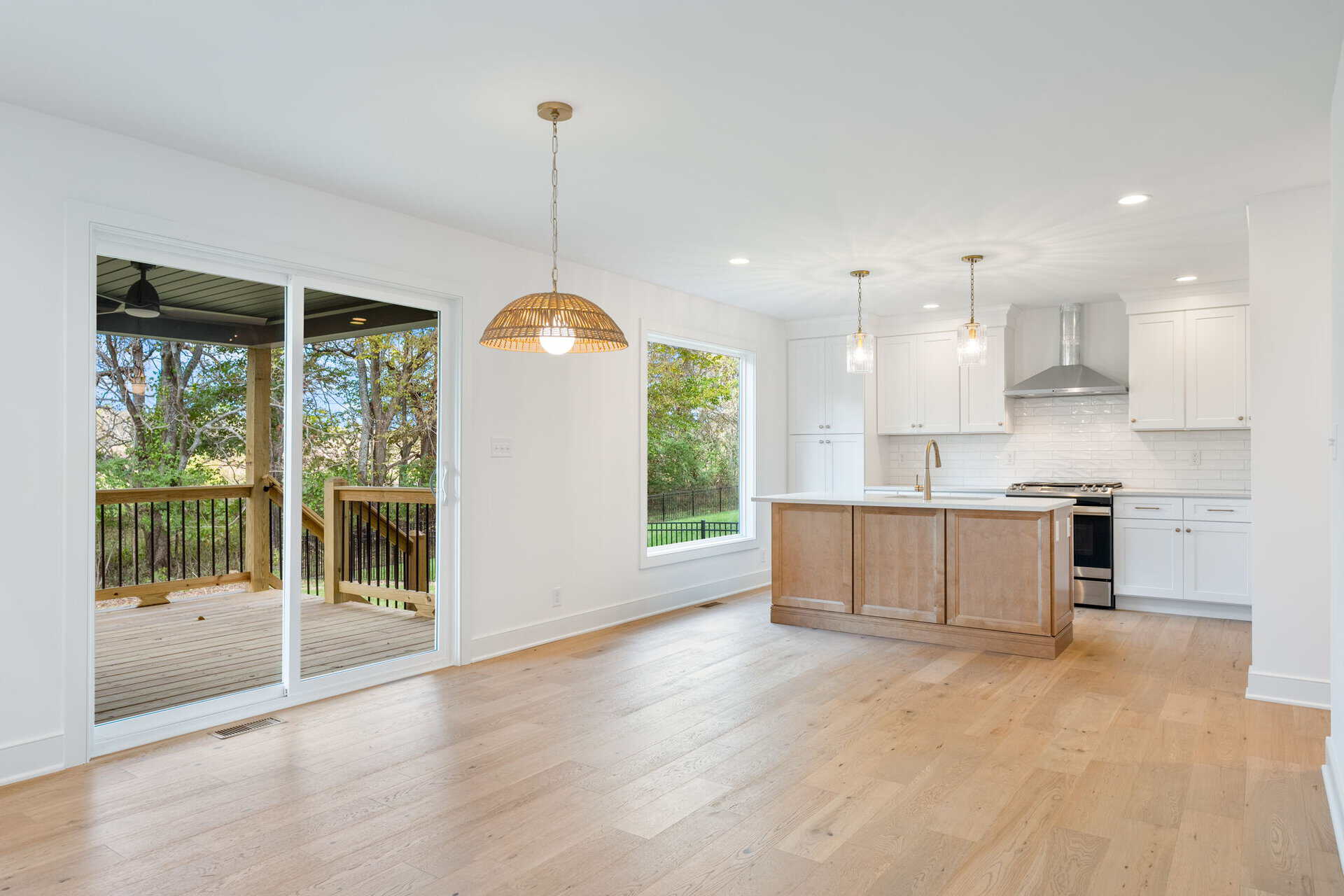 Open-concept kitchen and dining area with large sliding glass door to deck.