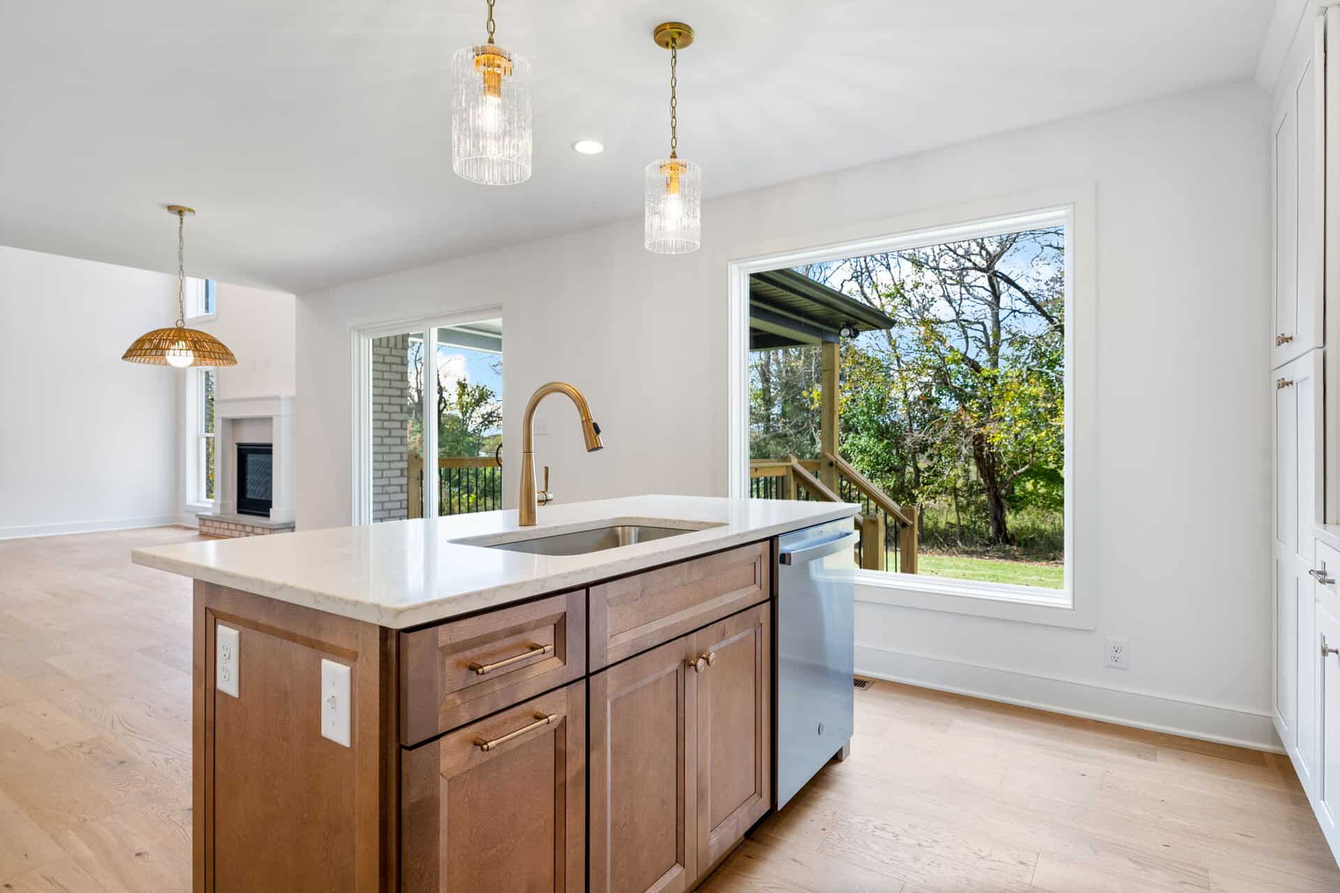 Modern kitchen with large window overlooking backyard and wooden island.