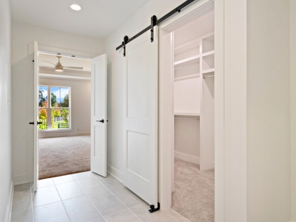 Bright hallway with sliding barn door leading to closet and adjacent room.
