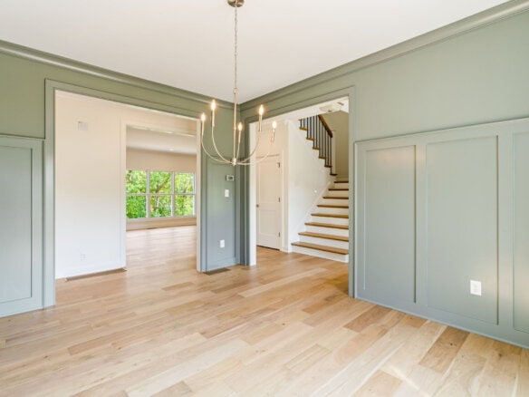 Bright interior with green walls, hardwood floors, and staircase at 6712 Hypoint Ridge Road.
