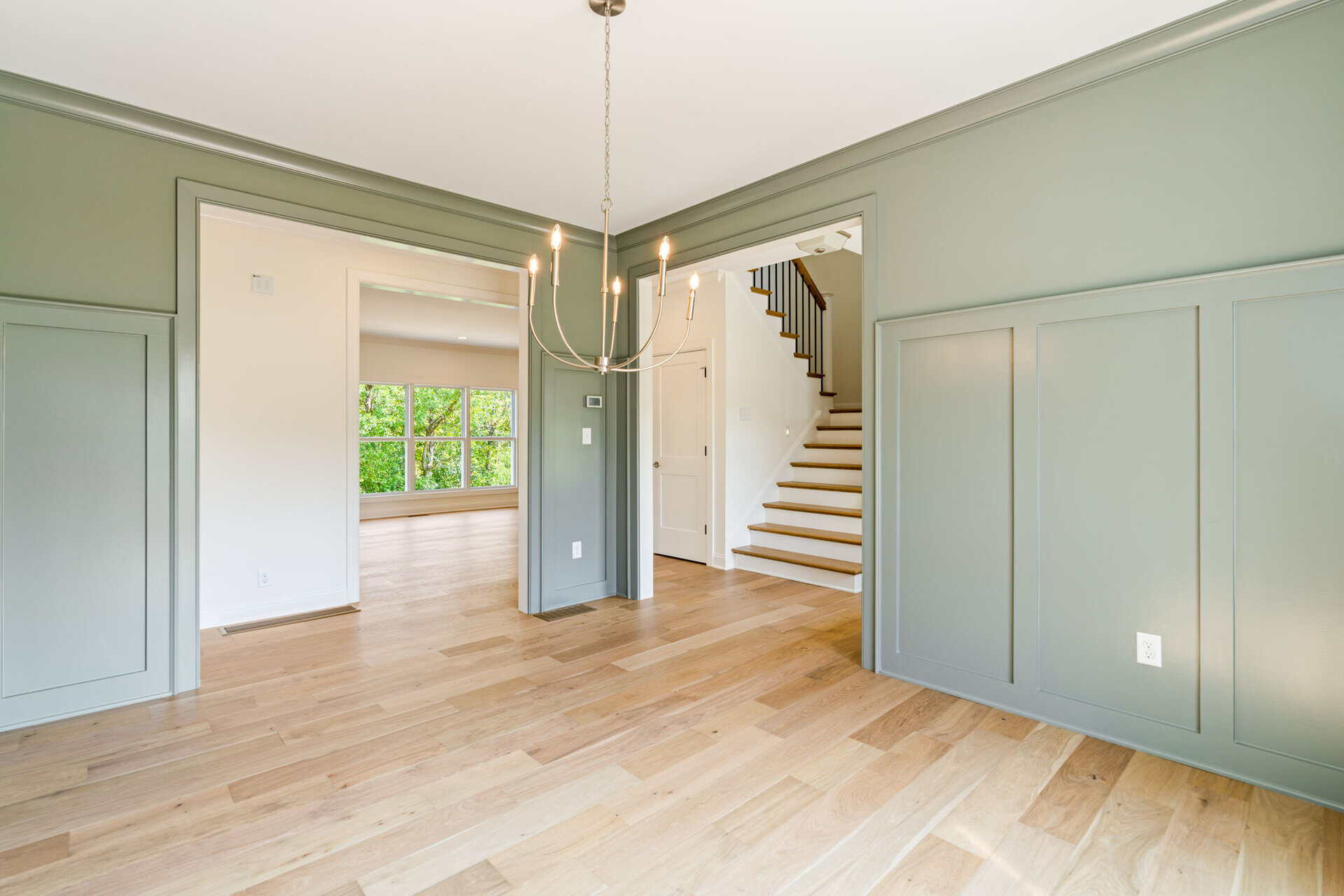 Bright interior with green walls, hardwood floors, and staircase at 6712 Hypoint Ridge Road.